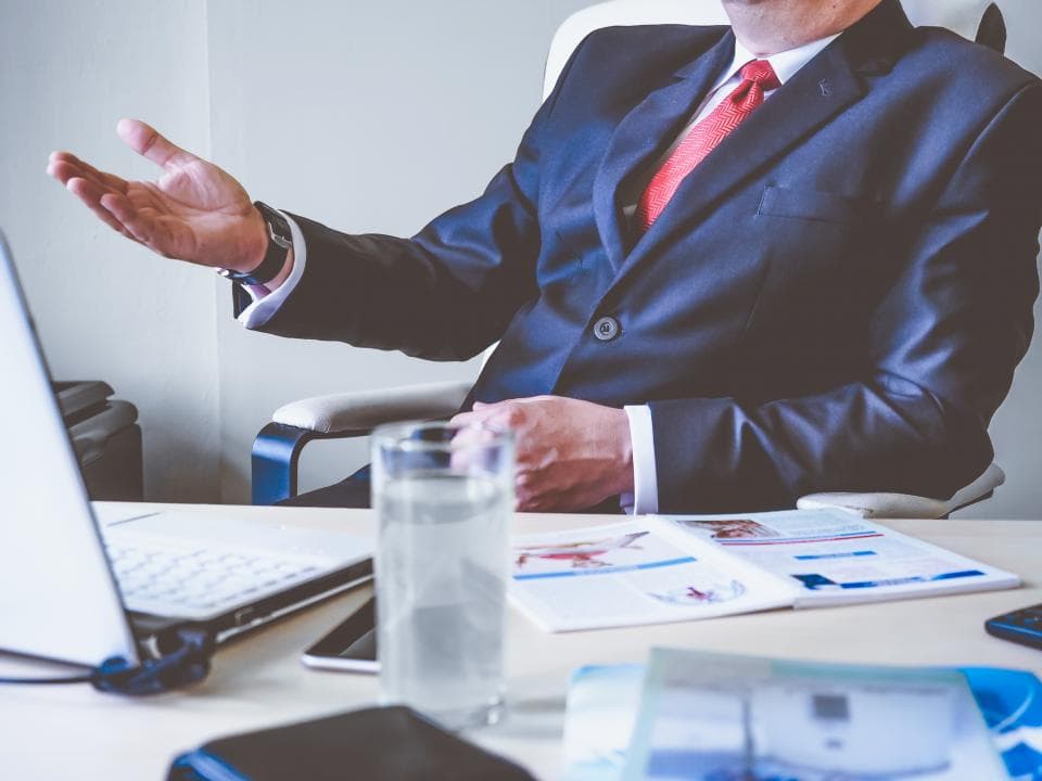Business adviser in a suit explaining figures at a desk