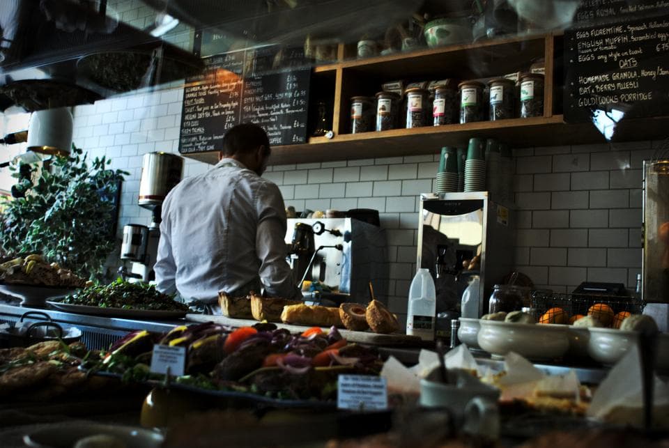 Busy cafe counter with a member of staff behind it